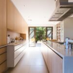 Harmonizing Your Kitchen: Vastu Principles for Ideal Layouts and Directions 3 white wooden kitchen island and cupboard cabinets near glass panel door